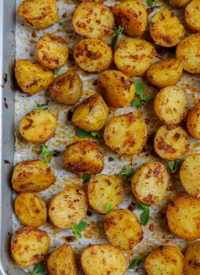 Top down shot of oven roasted baby potatoes on a sheet pan.