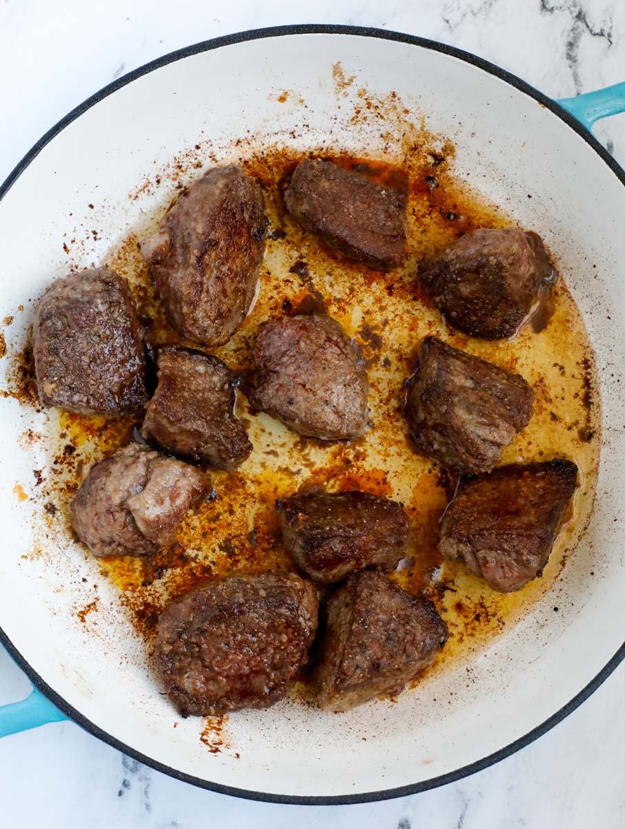 Beef cooking in a dutch oven.