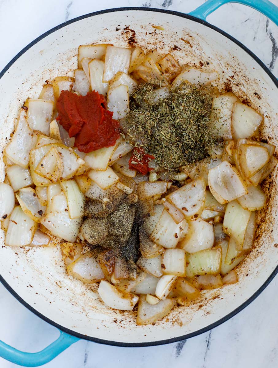 Onions and seasoning in a dutch oven.