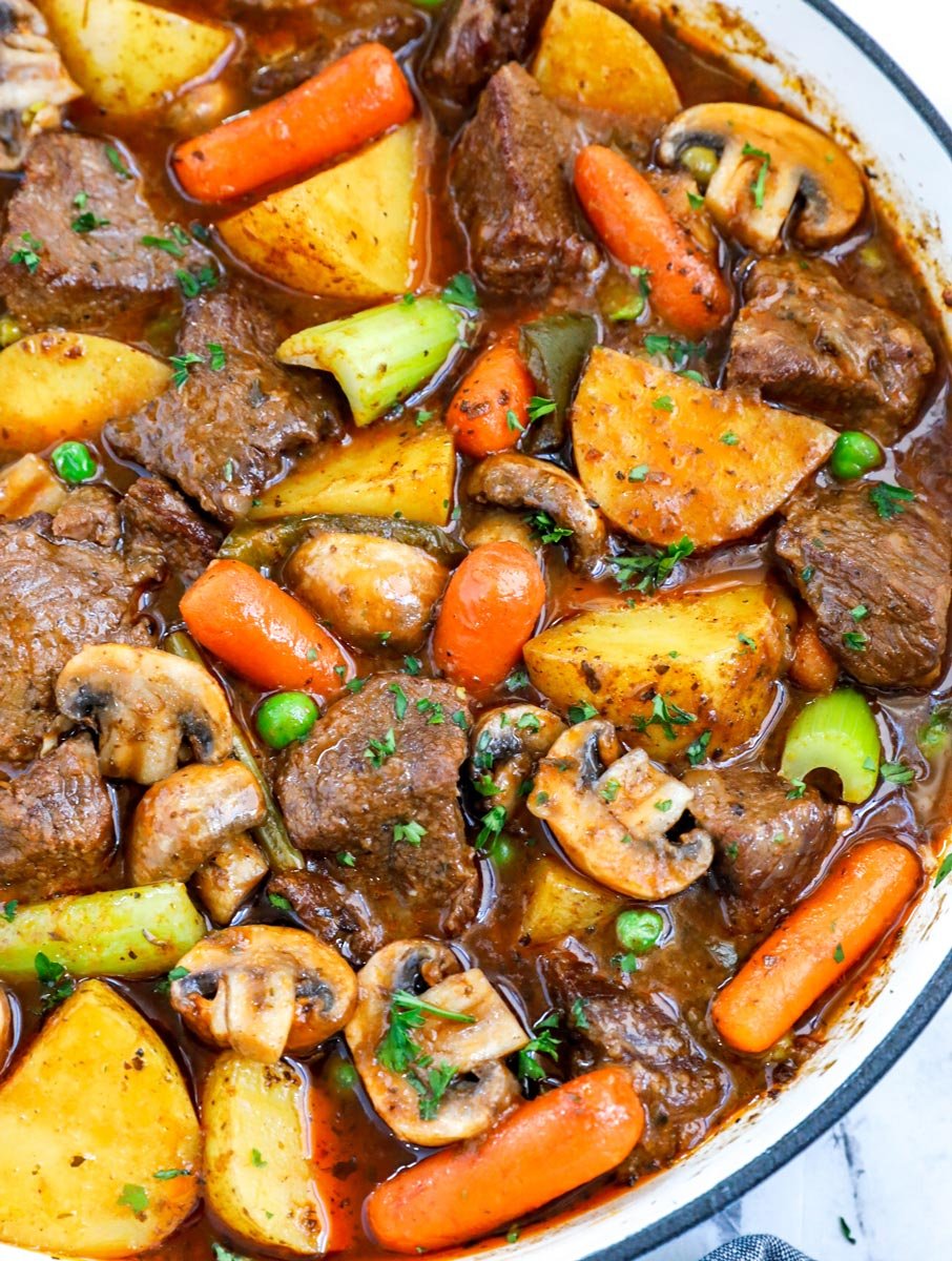 Overhead view of best beef stew in a big blue pot.