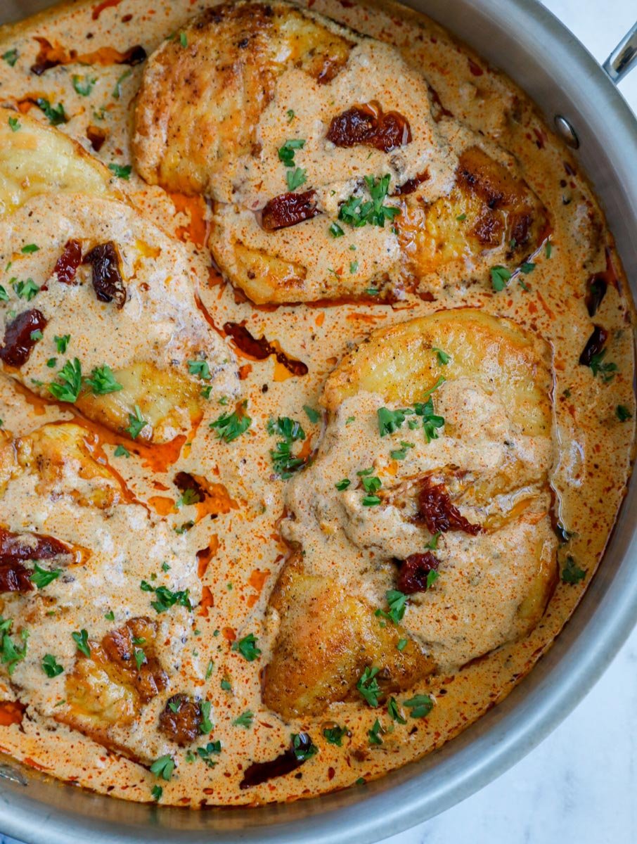 Close up of multiple chicken breast in cajun sauce.