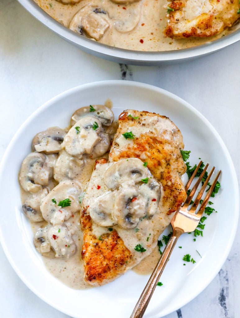 Top down view of creamy mushroom chicken on a plate. 