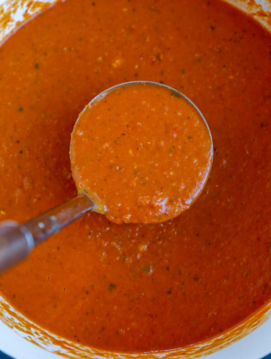 A ladle of creamy tomato soup.