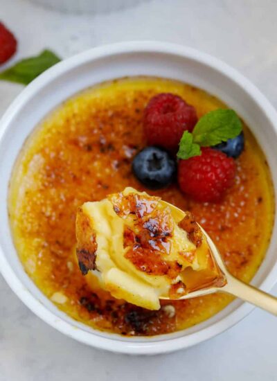 A spoon going into a pot of crème brûlée.