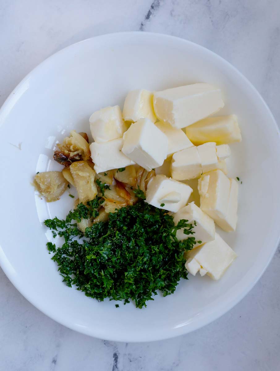 Herbs, butter and garlic in a bowl.