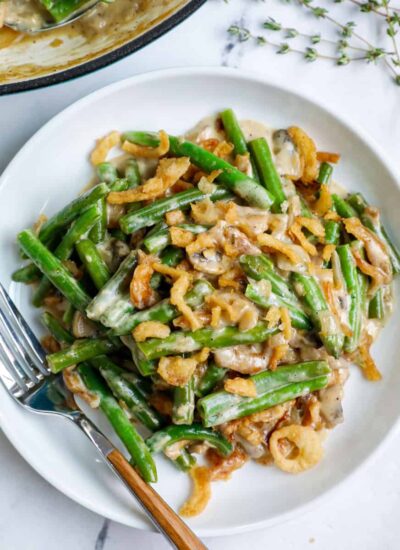 Top down shot of green bean casserole on a white plate.