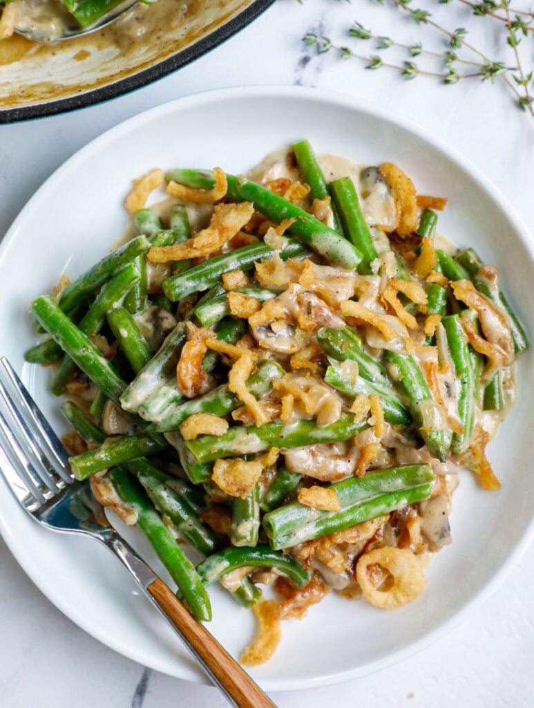 Top down shot of green bean casserole on a white plate.