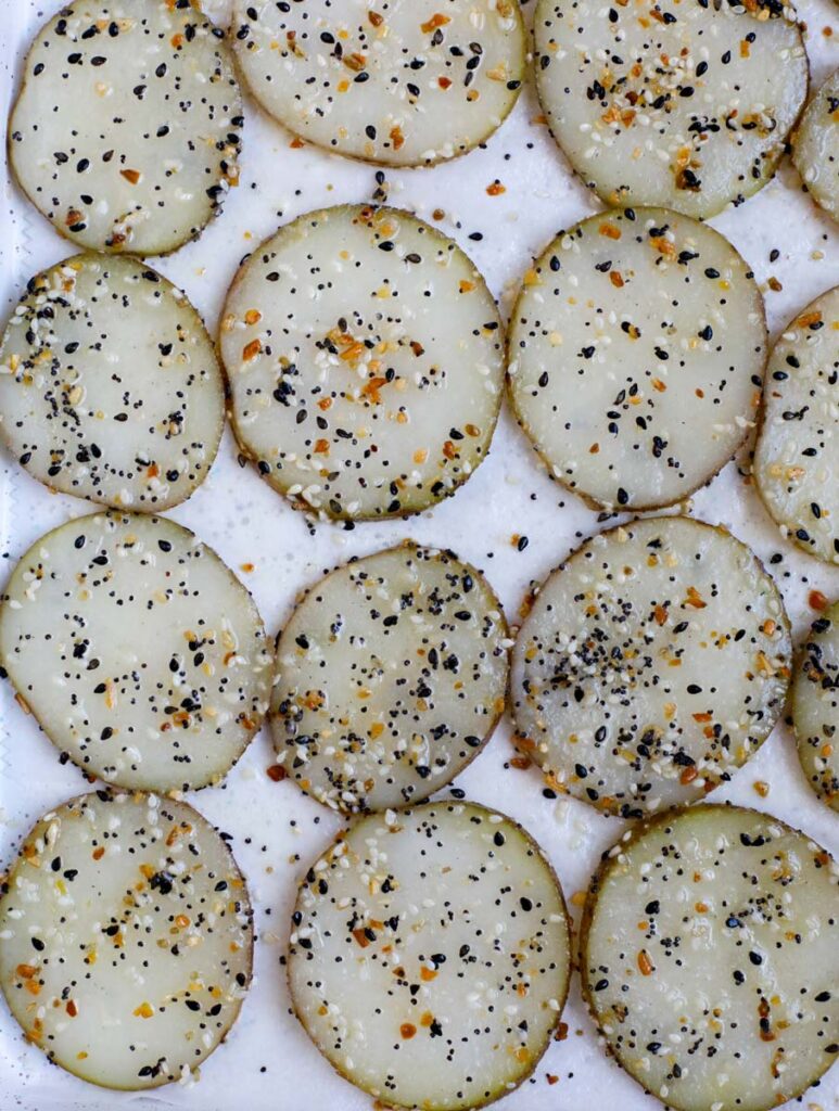 Overhead view of potato slices on a baking sheet.