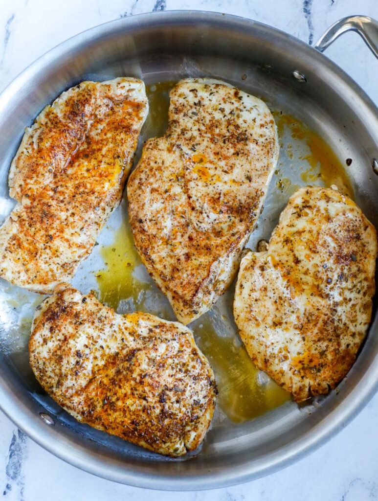 Top down shot of chicken breasts in a pot.