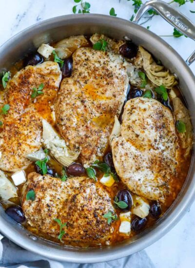 Top down shot of greek chicken in a skillet.