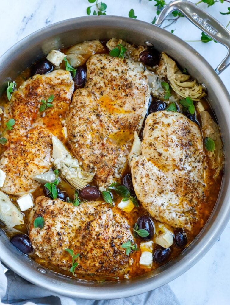 Top down shot of greek chicken in a skillet.