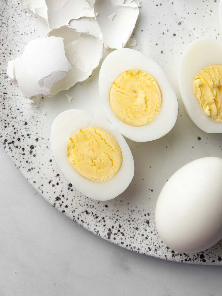 a hard boiled egg sliced in the middle showing the yolk.