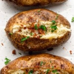 top down close up shot of baked potatoes topped with bacon and parsley