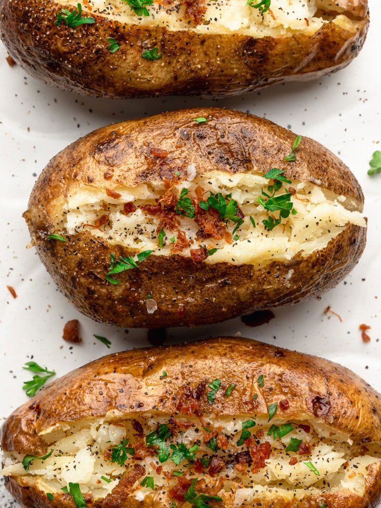 top down close up shot of baked potatoes topped with bacon and parsley