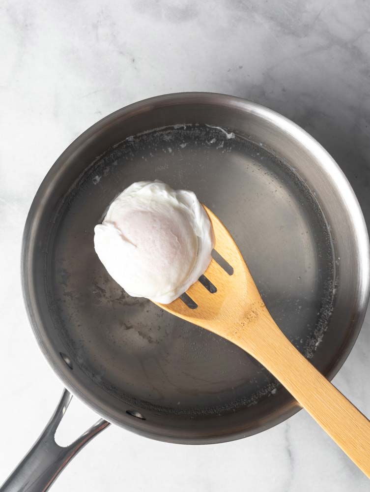 poached egg on a wooden spoon