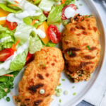 Top down shot of stuffed chicken with salad.