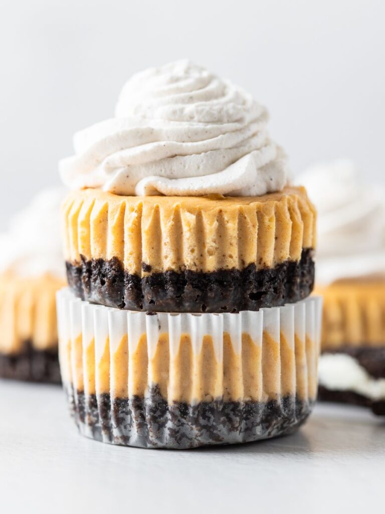 Side on shot of mini cheesecakes stacked on top of each other.