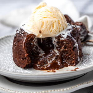 A lava cake cut opened with a scoop of ice cream on top.
