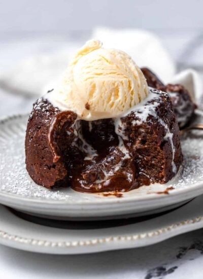 A lava cake cut opened with a scoop of ice cream on top.