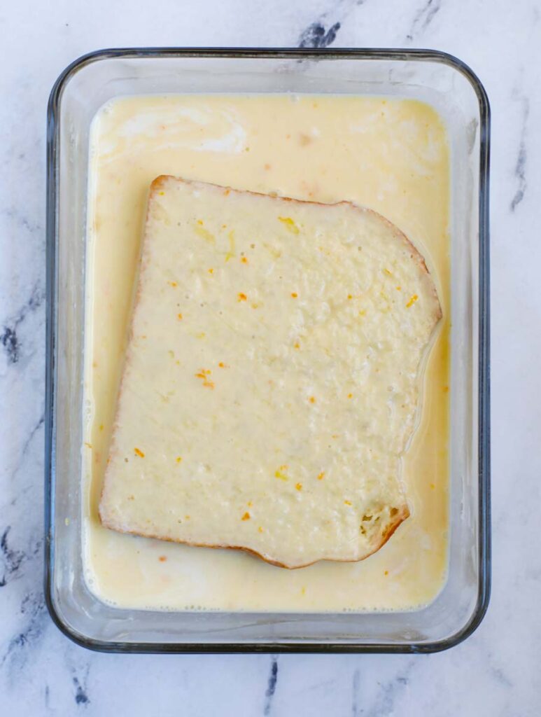 Flipping the bread in the custard mixture to soak both sides.