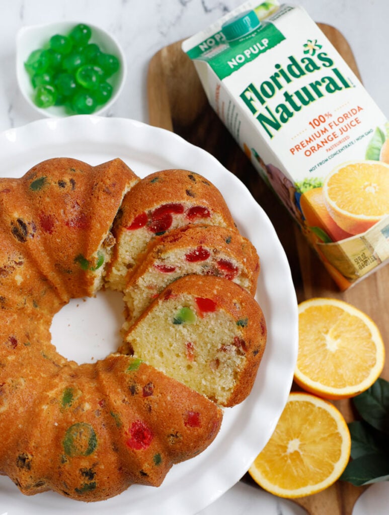 orange fruit cake served on a white dish with juice on the side