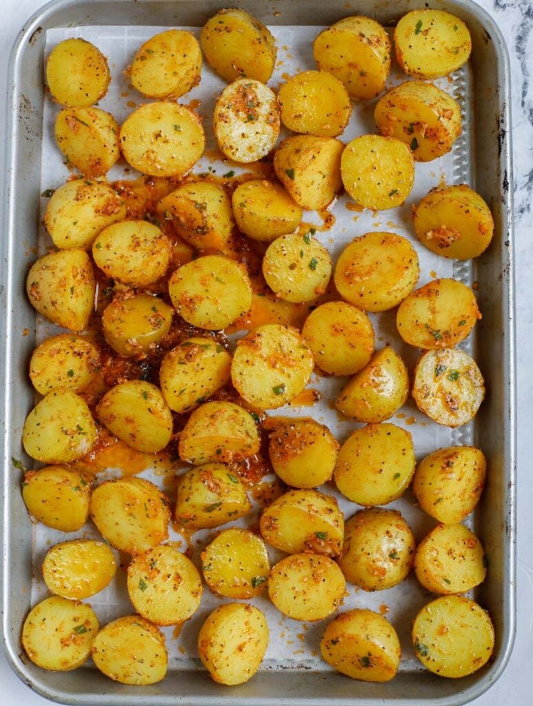 Top down shot of potatoes on a sheet pan before roasting.
