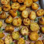 Top down shot of oven roasted baby potatoes on a sheet pan.
