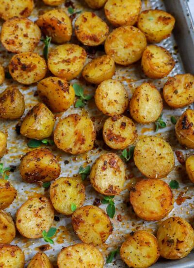 Top down shot of oven roasted baby potatoes on a sheet pan.