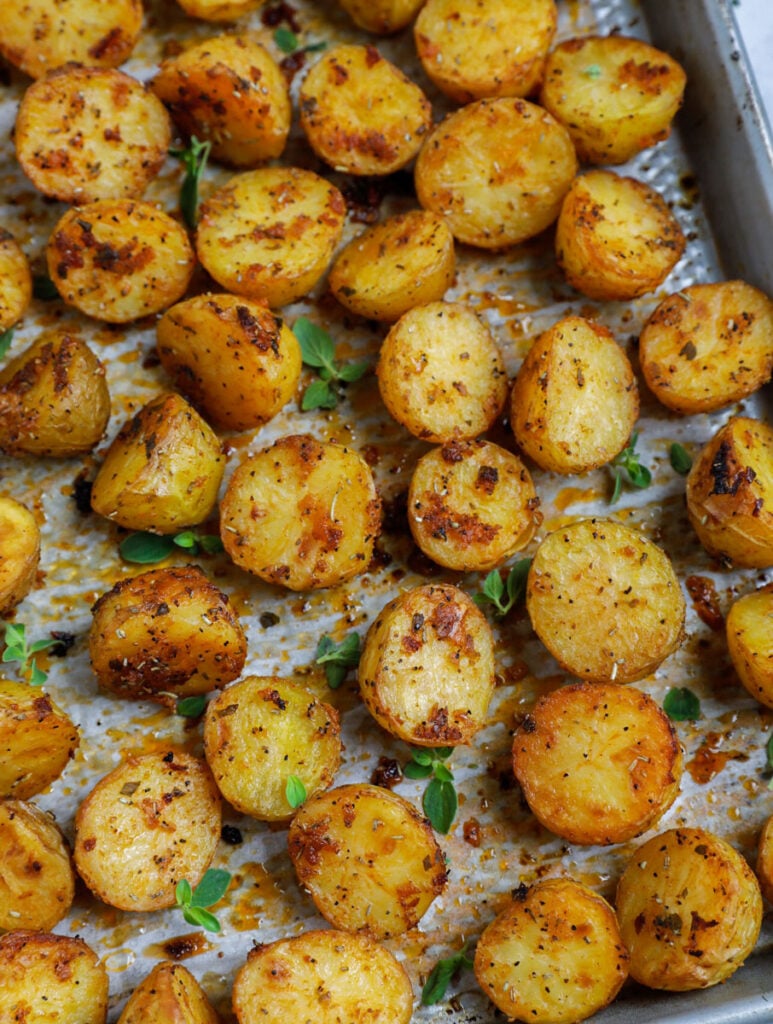 Top down shot of oven roasted baby potatoes on a sheet pan.