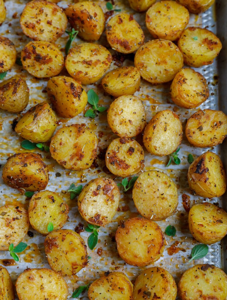 Top down shot of oven roasted baby potatoes on a sheet pan.