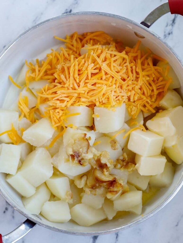 Potatoes, cheese and other ingredients in a pot.