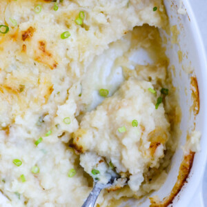 Top down view of mashed potatoes in a baking dish with a portion taken out.