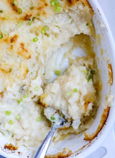 Top down view of mashed potatoes in a baking dish with a portion taken out.