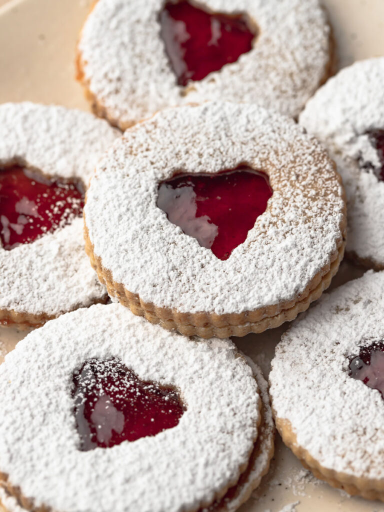 Close up of multiple strawberry jam linzer cookies.