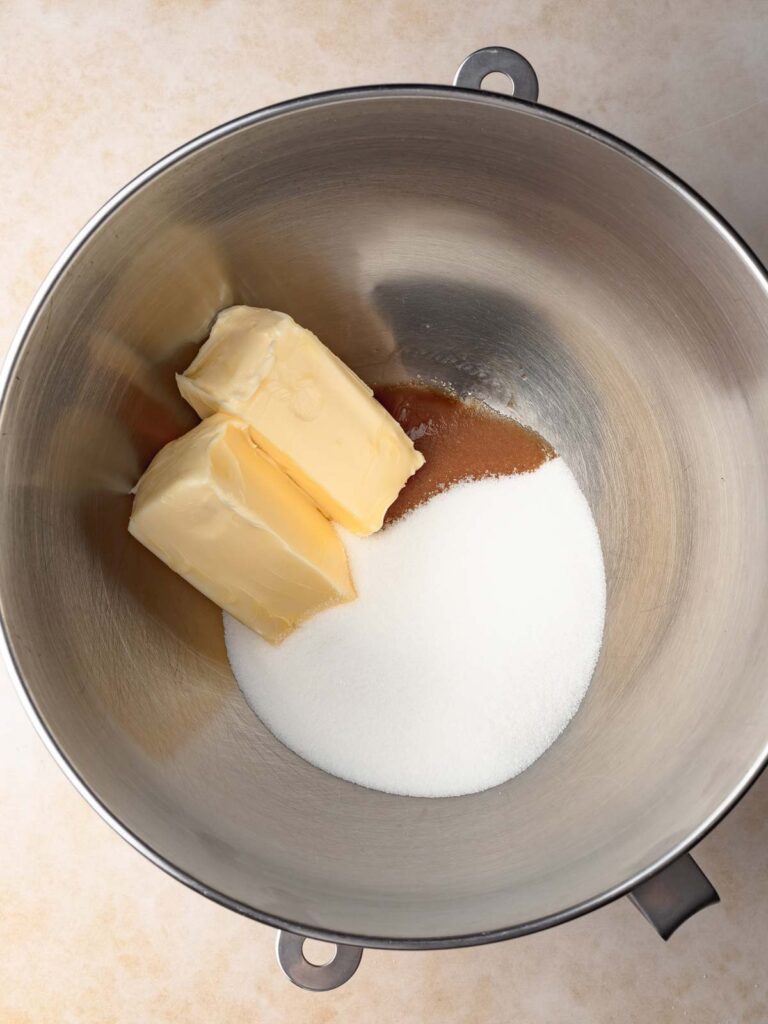 Butter, sugar, and vanilla inside of a mixing bowl.