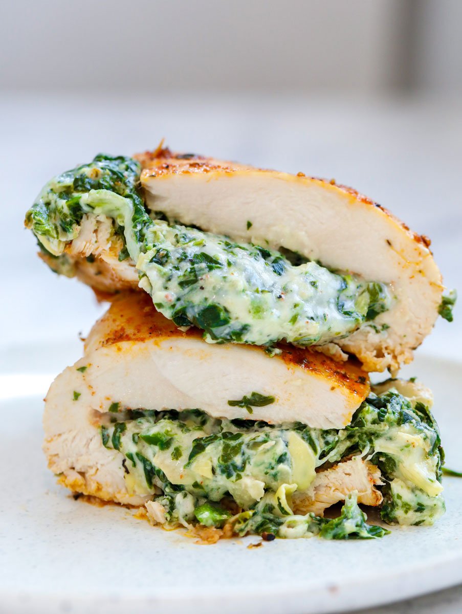 Cheesy spinach stuffed chicken breast cut in half and stacked on top of each other.