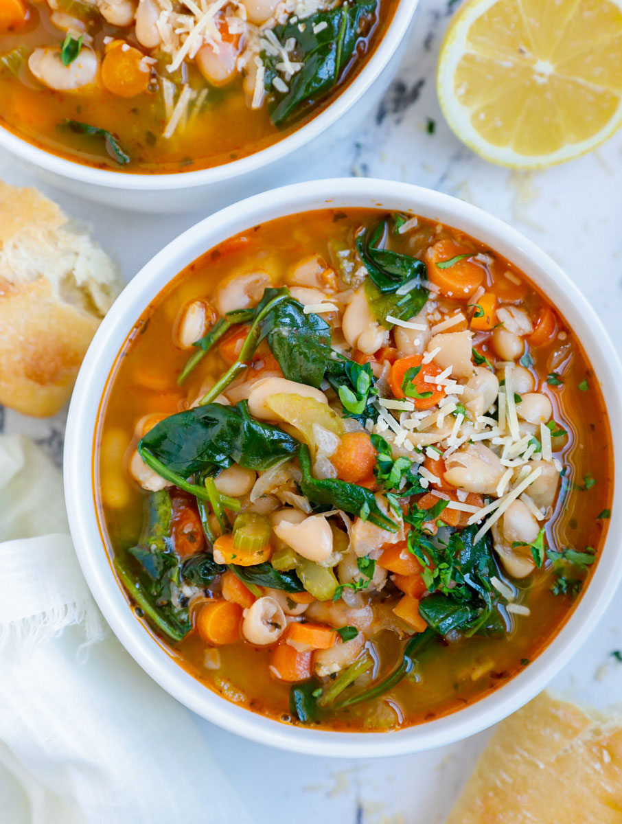 Overhead photo of a bowl of white bean soup with bread beside it.