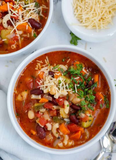 Top down shot of vegetable minestrone soup in two bowls.