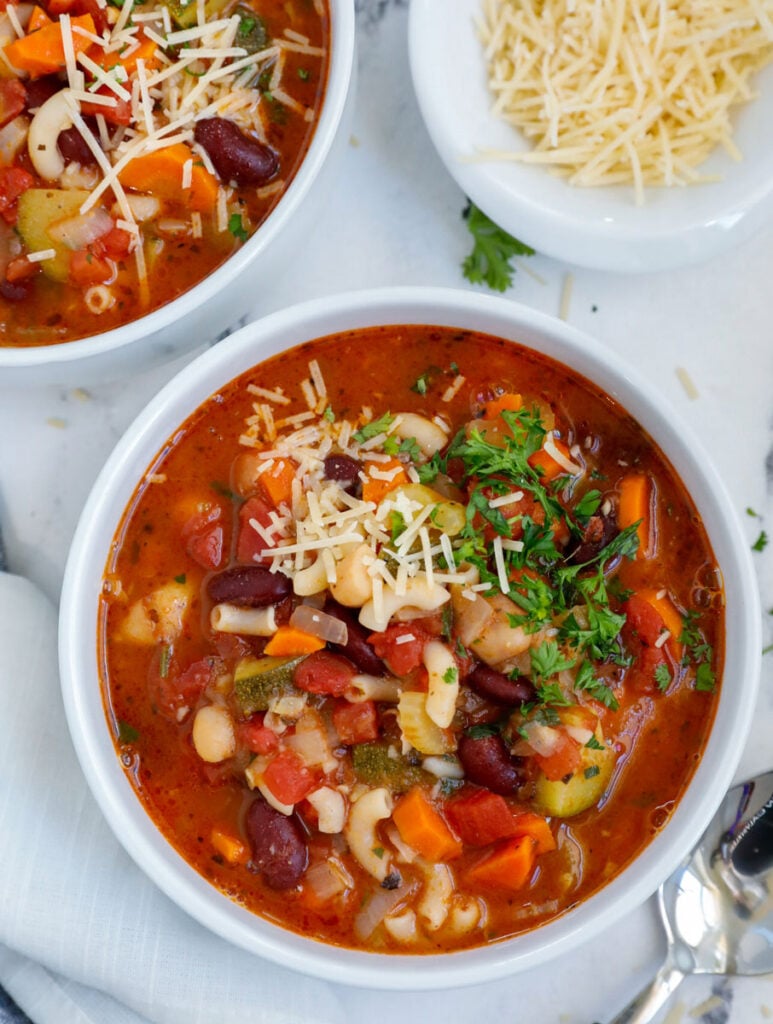 Top down shot of vegetable minestrone soup in two bowls.