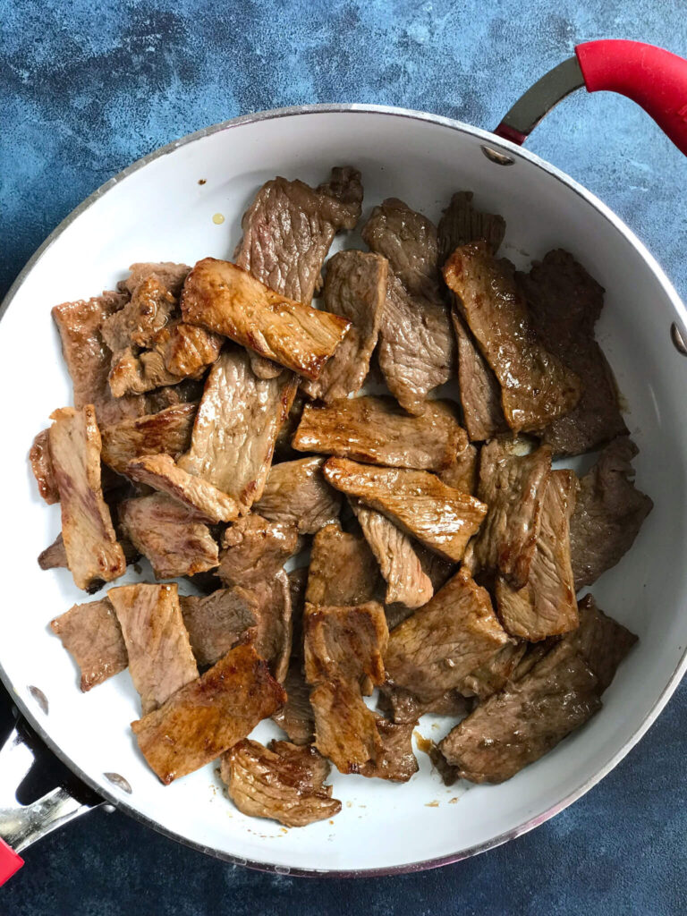 Steak in a white skillet, fully cooked