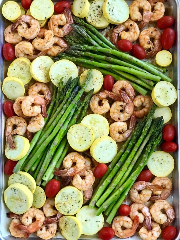 A sheet pan of sriracha garlic shrimp, squash, tomatoes, and asparagus