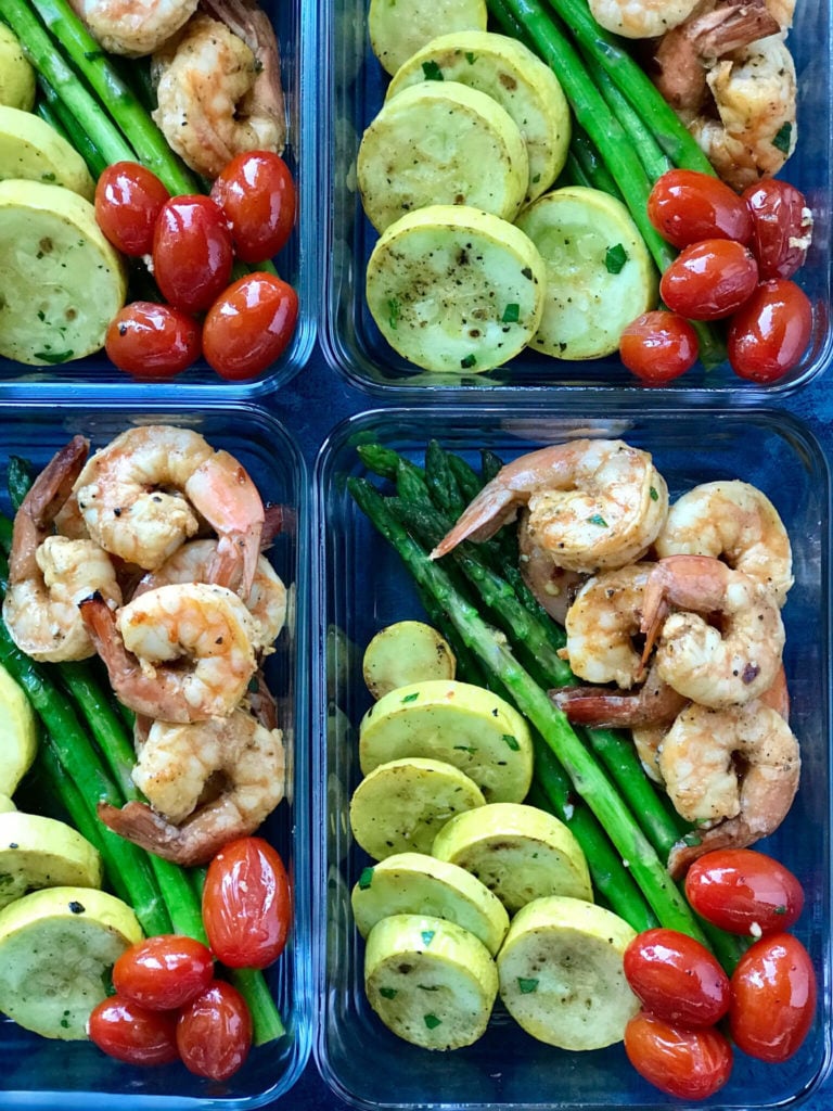 Sriracha Garlic Shrimp in small meal prep containers with squash, tomatoes, and asparagus 