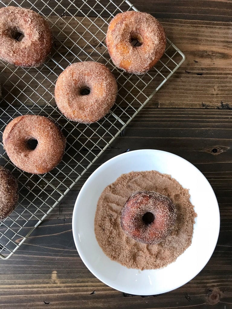  Cinnamon Sugar Donut in a dish of sugar.