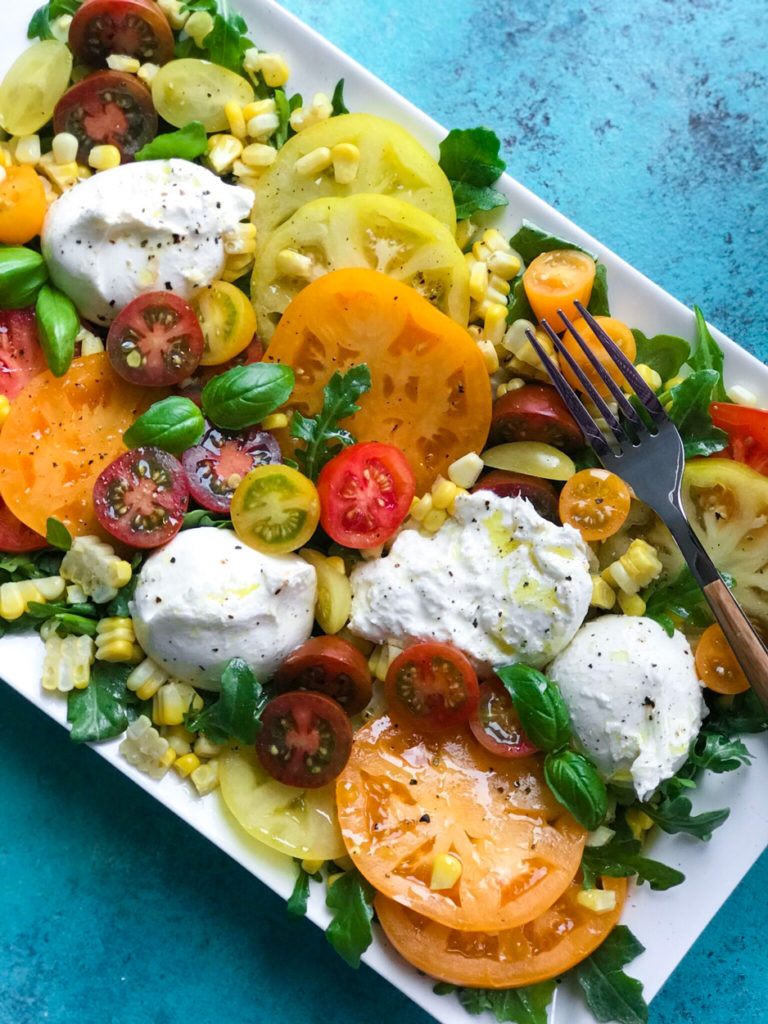 close up of tomatoes and burrata on a plate