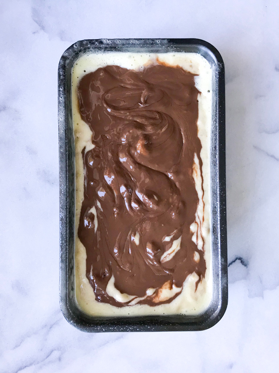Banana bread batter with Nutella swirls in a loaf pan
