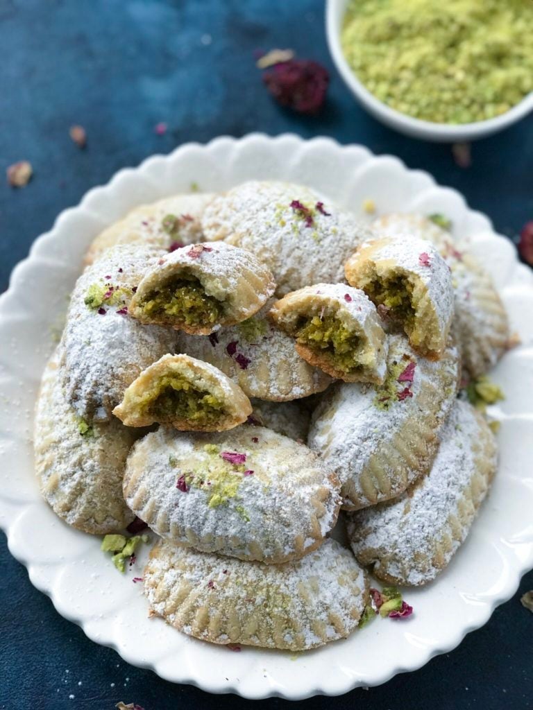 Pistachio Maamoul Cookies ( معمول بالفستق ) on a white plate with some broken in half