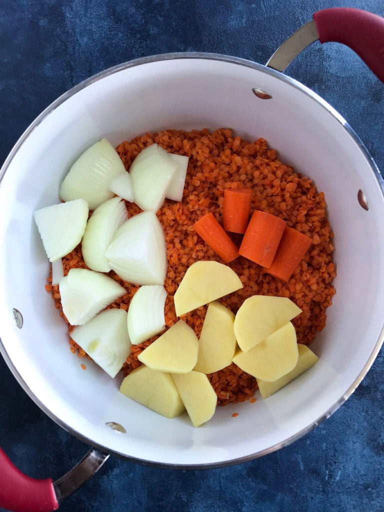 The vegetables and red lentils in a pot.