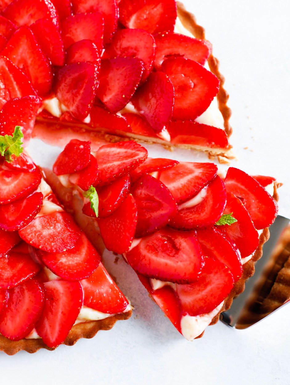 Strawberry French Tarte with a slice being taken out.