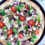 Mediterranean Veggie Pizza with delicious pesto sauce, topped with some alfredo sauce, and packed with fresh veggies and cheese.