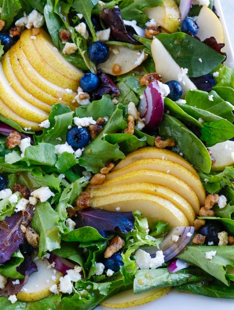 pear and blueberry salad on a white plate.